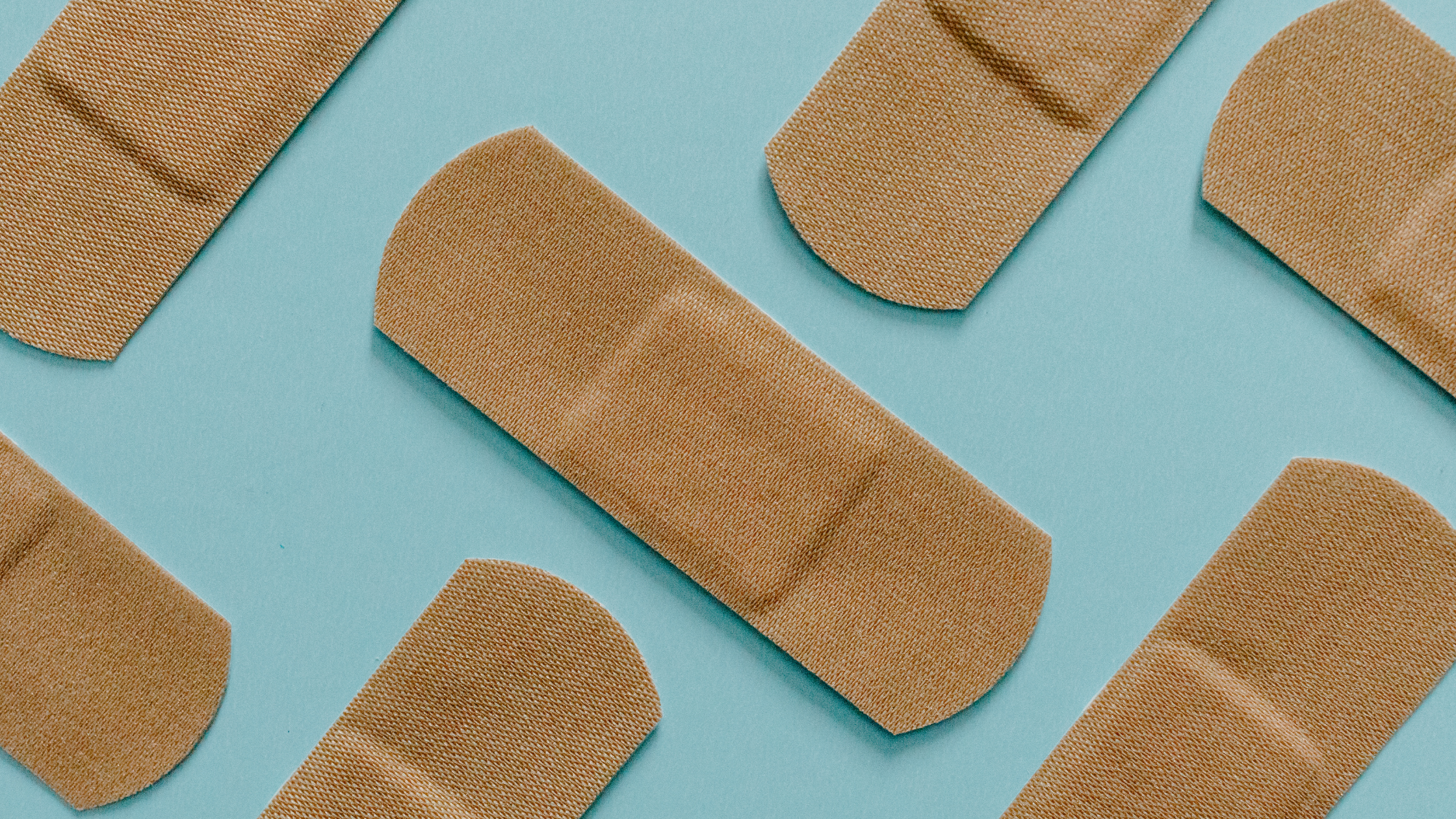 Bandaids spread out on a light blue background